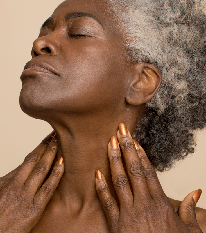 Older black woman with eyes closed and showing off neck area